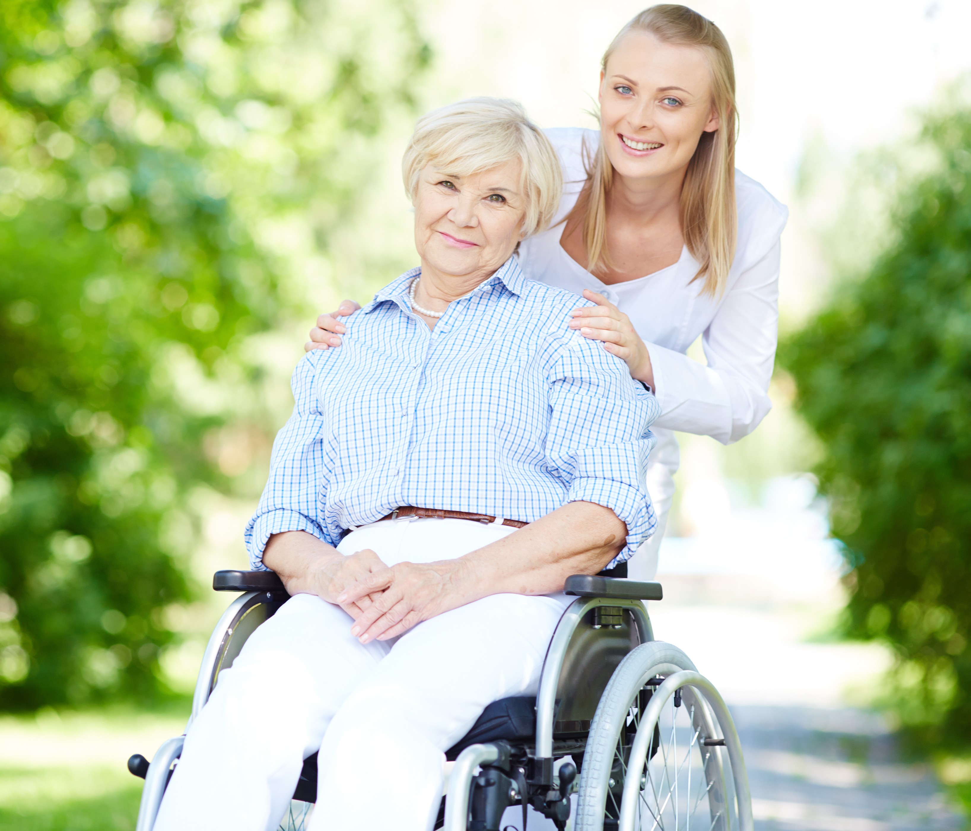 caregiver pushing senior woman in wheelchair